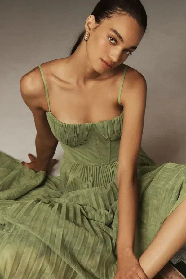 Chic women's A-line midi dress with bustier top, delicate spaghetti straps, and flowy pleated skirt.