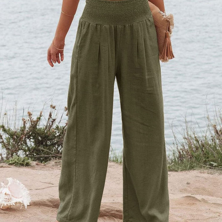 Details of women's pleated wide leg trousers, showcasing the elastic waistband & fabric texture.