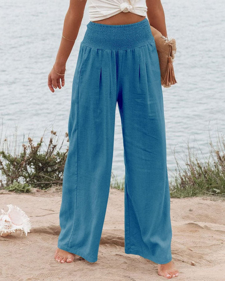 Linen blend wide leg women's pants. Features elastic waist and elegant pleats for summer style.