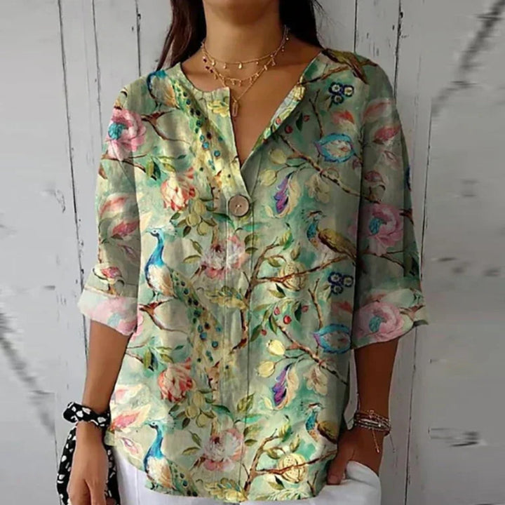 Vibrant floral print plus size V-neck blouse for women. Button-up, relaxed fit for spring/summer.