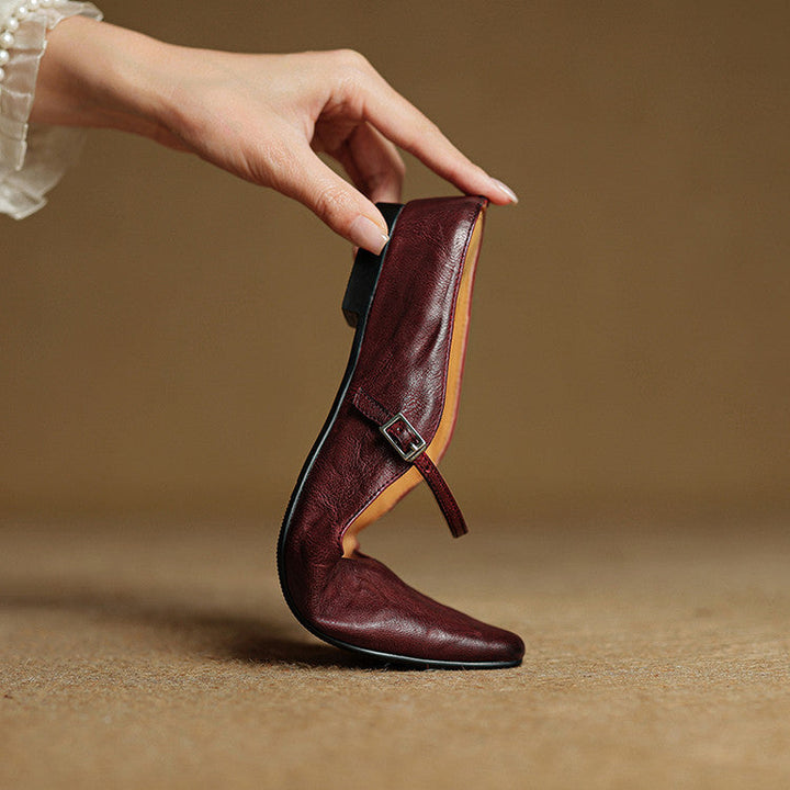 Black women's pointed toe slip-on mule flats with an elegant strap detail.