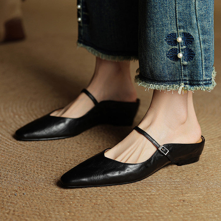 Women's pointed toe mule flats, elegant black, with a refined strap accent.