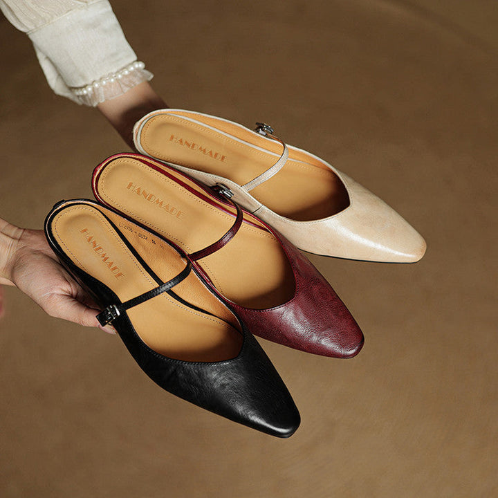 Fashion-forward women's pointed toe mules, black, strap detail for a trendy look.