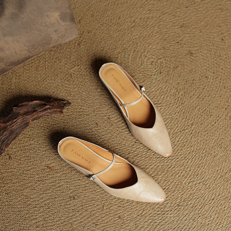 Chic women's pointed toe mule flats, modern design, decorative strap feature.