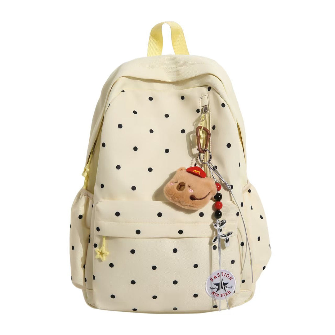 Fashionable women's travel backpack, polka dot pattern, embellished details, and a decorative charm.