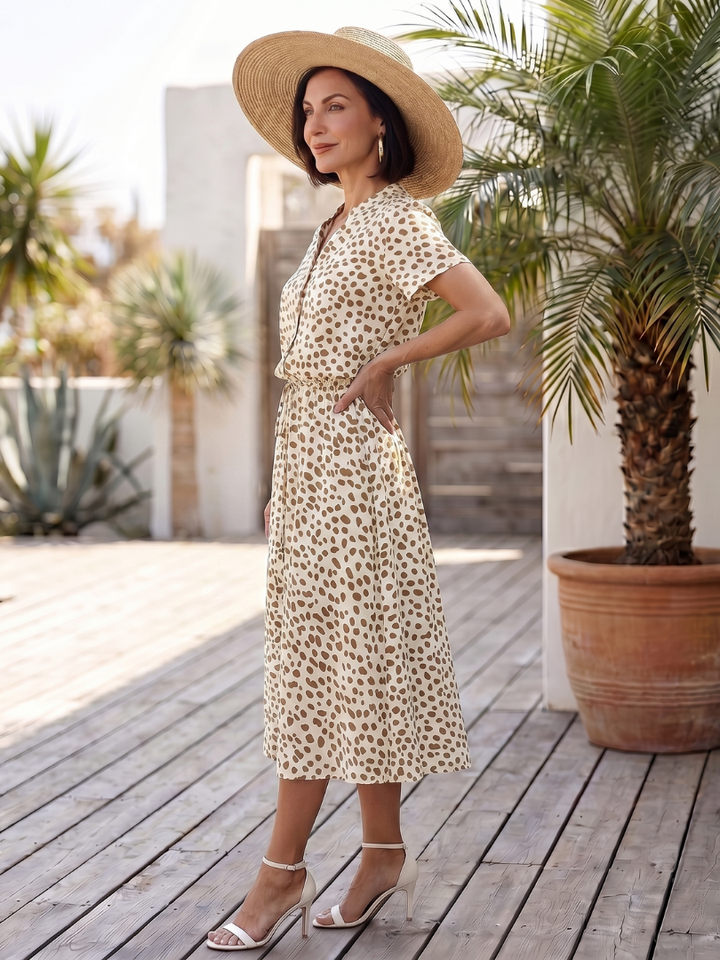 Chic printed women's midi dress, features a full button front, short sleeves, and a flattering belted silhouette.