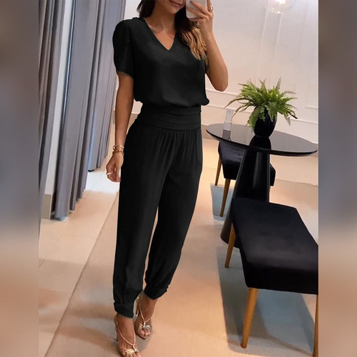 Women's printed v-neck wide leg jumpsuit with tie waist, perfect for relaxed summer style. Casual yet elegant.