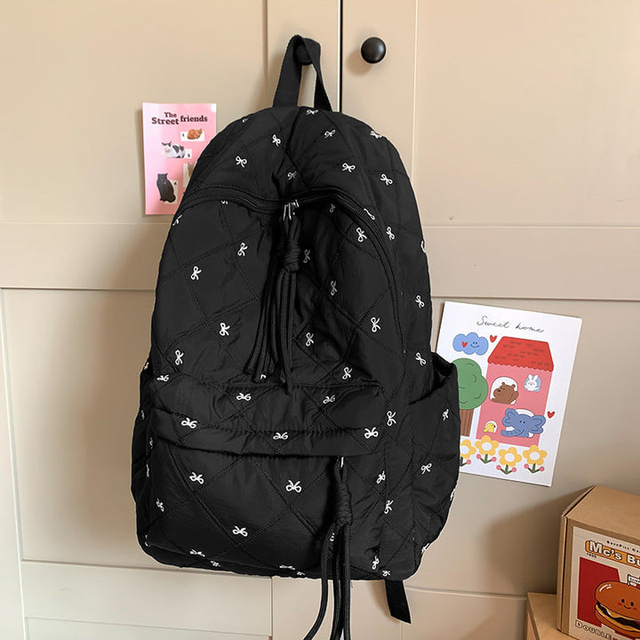 Stylish women's quilted backpack featuring a prominent decorative bow, ideal for daily travel.