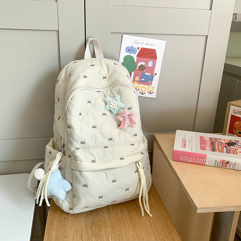 Fashionable women's quilted backpack, adorned with a pretty front bow; versatile chic accessory.