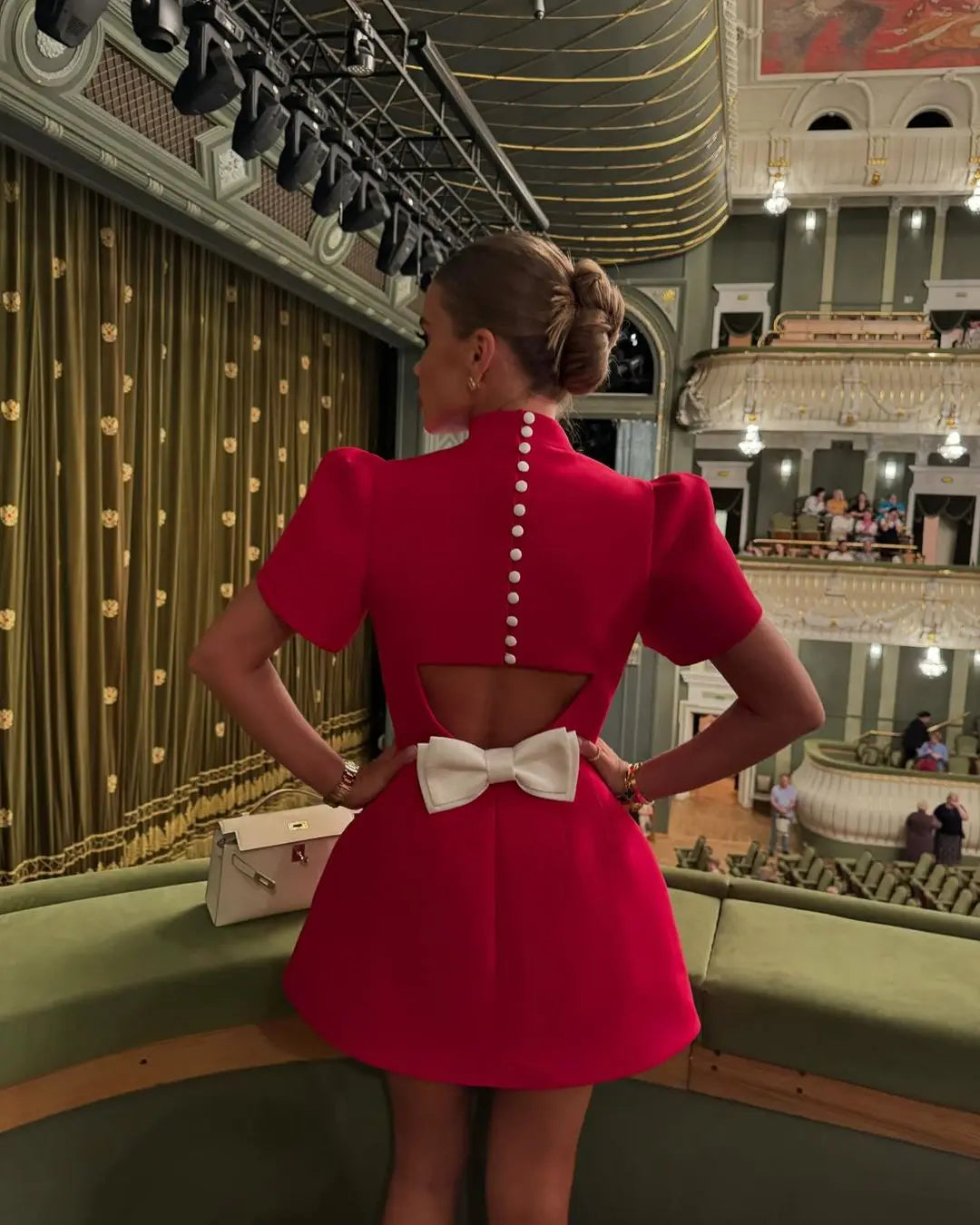Elegant women's short skater dress in red, featuring a unique back bow, great for any special event.