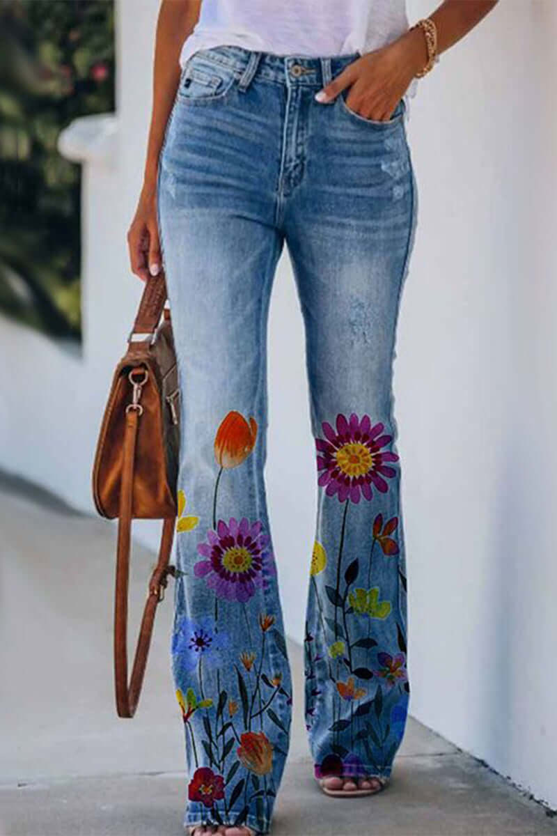 Close-up: Delicate floral embroidery on women's blue denim regular fit jeans. Unique, stylish, comfortable.