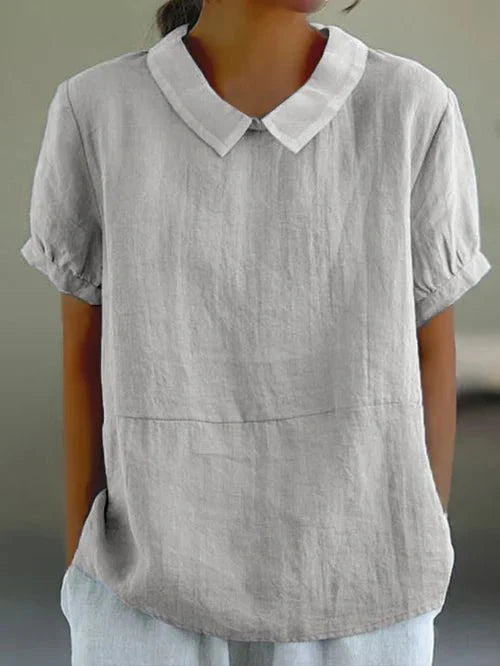 Chic women's relaxed-fit blouse featuring a stylish Peter Pan collar and short sleeves. Ideal for spring fashion.