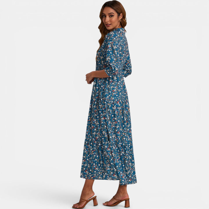 Woman comfortably sitting in a relaxed fit V-neck floral maxi dress, comfortable wear.