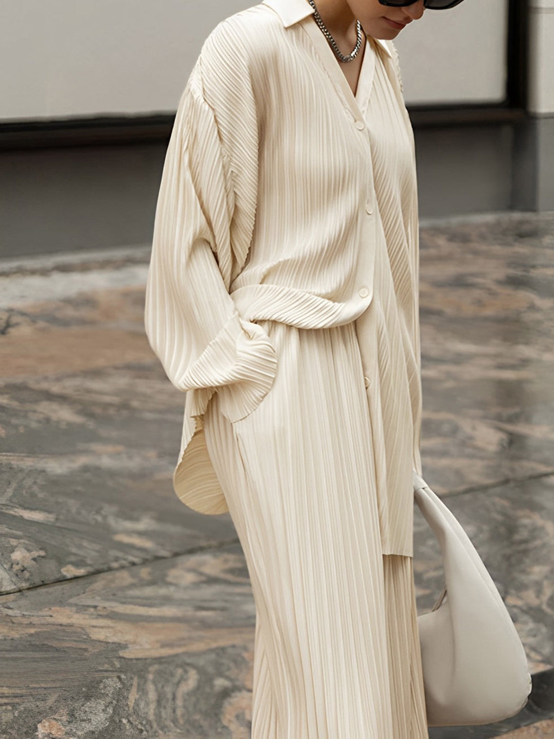 Chic women's pleated co-ord set featuring a relaxed top and wide-leg trousers for versatile fashion.