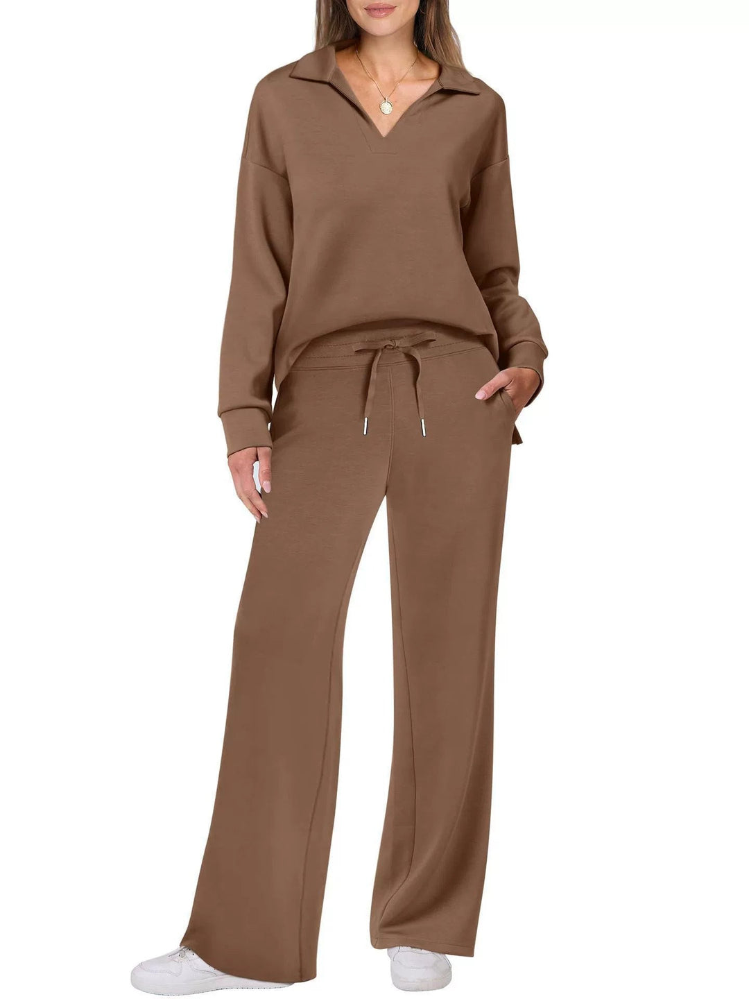 Full-length shot of women's activewear set: zip-neck top and wide-leg casual pants.