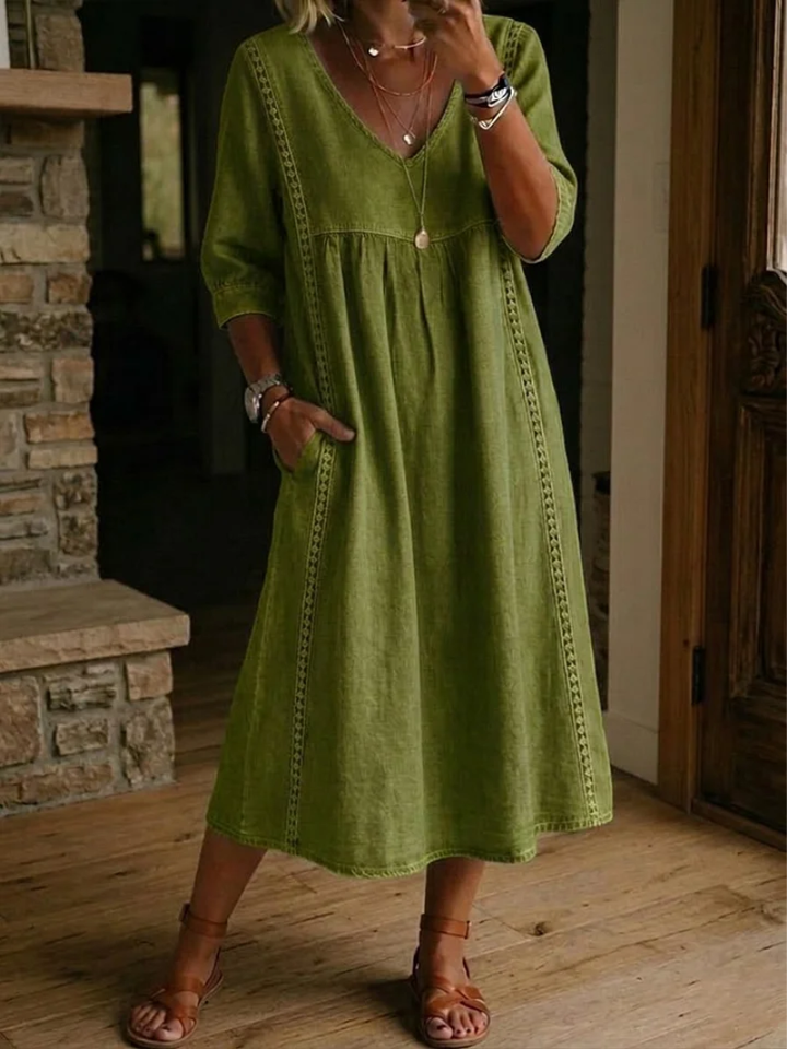 Flowy women's midi dress featuring a stylish V-neck and practical pockets. Relaxed fit for comfortable daily spring wear.