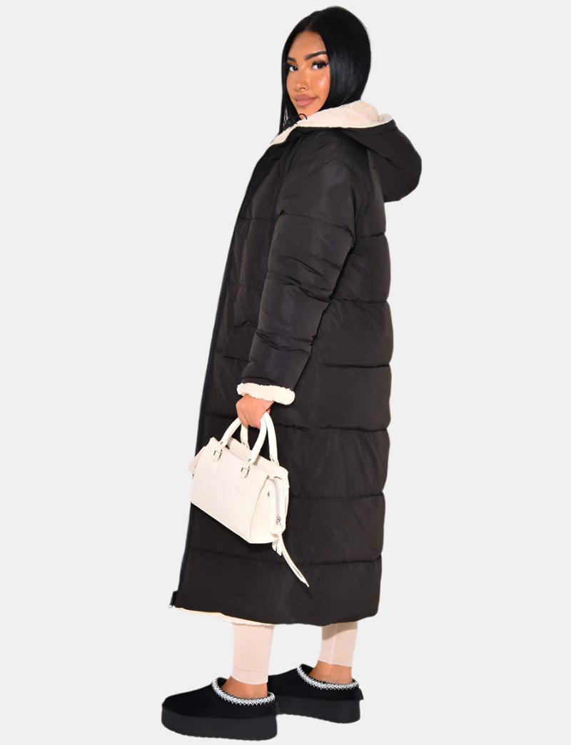 Reversible women's long puffer jacket, offering versatile style for cold weather with a cozy hood.