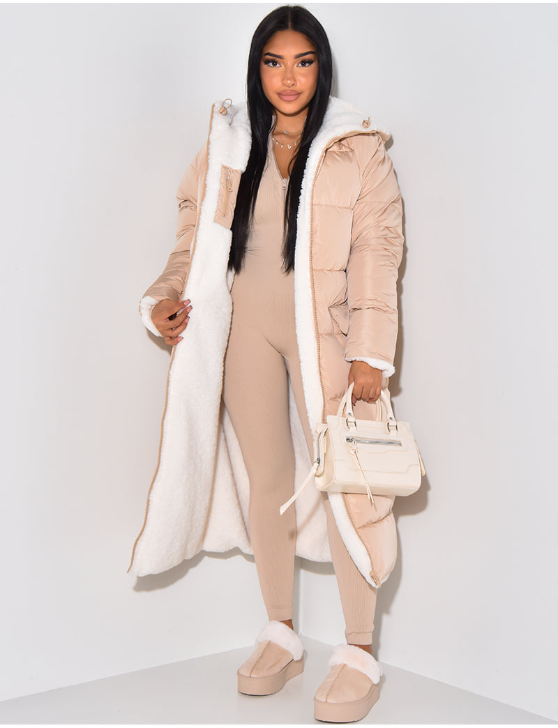 Woman wearing a long reversible puffer winter jacket, staying warm and stylish in cold weather.