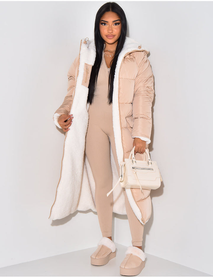Woman wearing a long reversible puffer winter jacket, staying warm and stylish in cold weather.