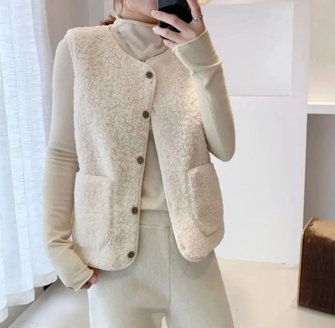 Warm women's reversible puffer vest. Button-up sleeveless jacket for cozy winter fashion, featuring sherpa fleece.
