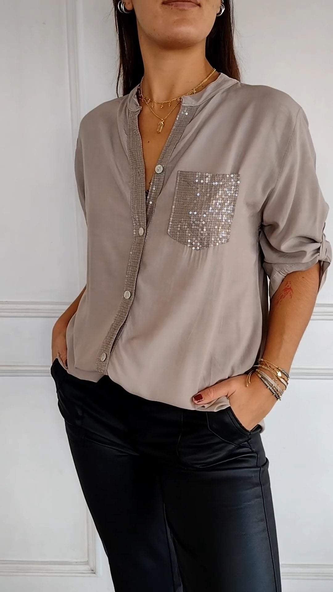 Women's button-up shirt accented with sparkling sequin trim, an elegant and eye-catching blouse.
