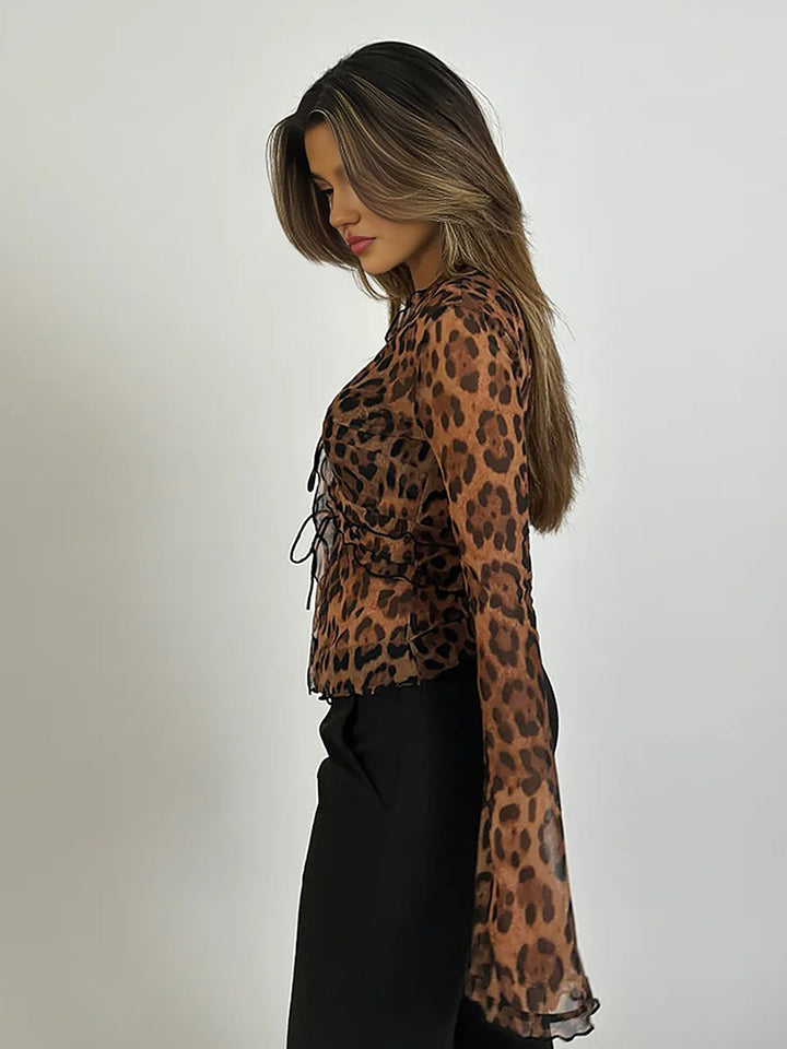Elegant women's sheer animal print top with ruffles, tie front, and long flared sleeves, ideal for evening fashion.