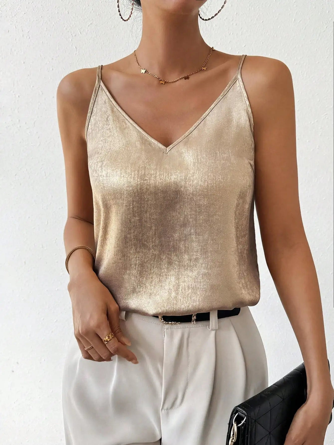 Back view of a women's metallic V-neck cami top, showcasing adjustable spaghetti straps for a custom fit.