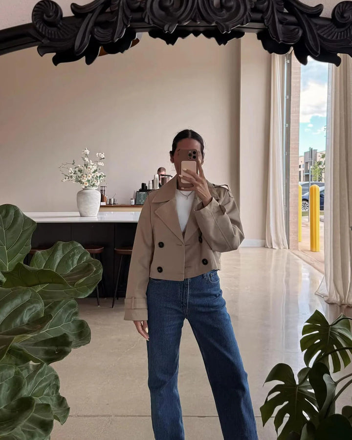 Classic women's short trench coat, double-breasted. Ideal transitional outerwear for elegant smart casual looks.