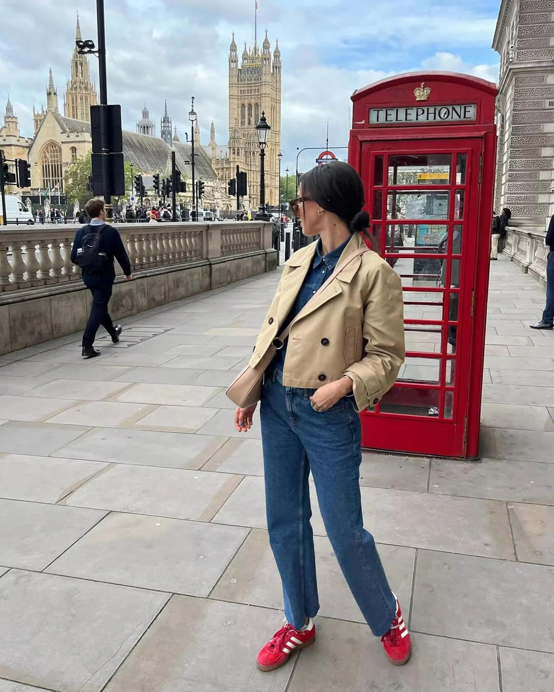 Woman modeling elegant short double-breasted coffee trench coat. Classic outerwear for smart casual women's fashion.