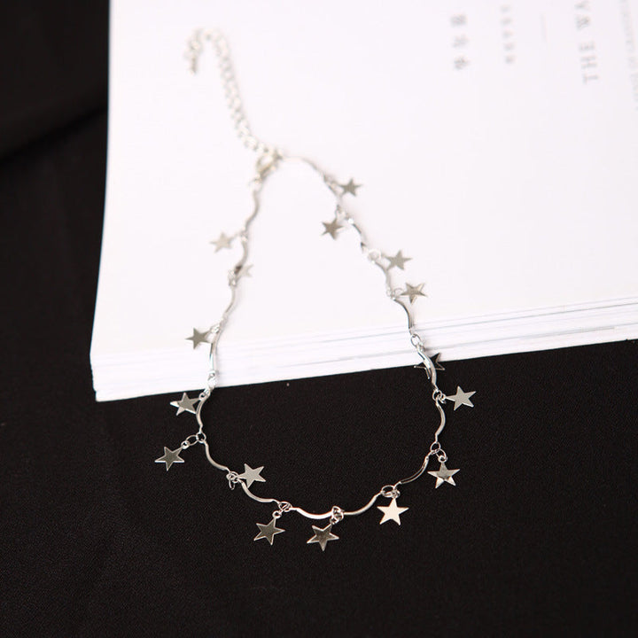Stylish women's celestial star charm necklace; adjustable silver tone linked chain for versatile fashion looks.