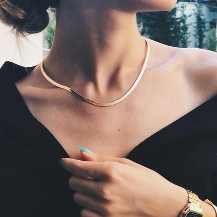 Women's sleek gold snake chain necklace. Elegant minimalist fashion accessory, perfect for layering.