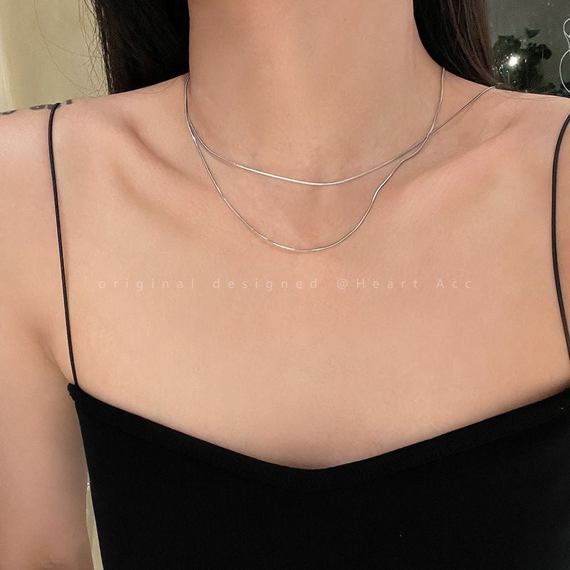 Elegant women's layered chain necklace, sleek design with gold and silver-tone metal, a stylish jewelry piece.