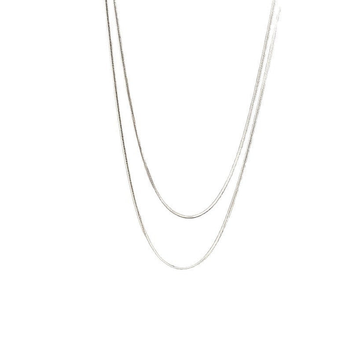 Close-up of a women's layered chain necklace, sleek gold and silver tones, ideal elegant gift for her.