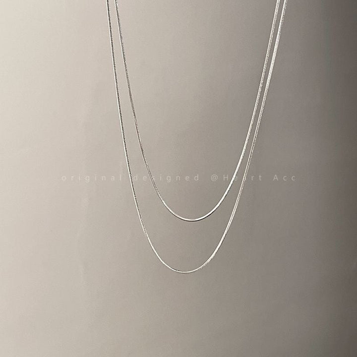 Beautiful women's layered chain necklace, sleek gold and silver tones, a modern and elegant jewelry accessory.