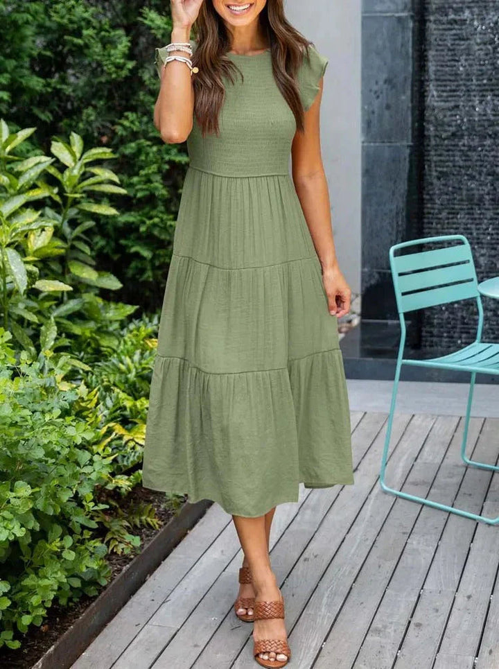 Casual women's sleeveless midi dress with smocked bodice, great for summer vacation.