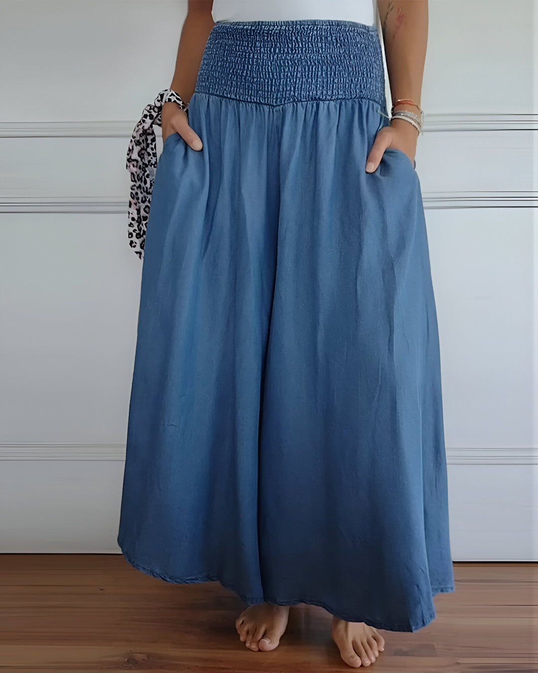 Women's smocked maxi skirt with wide waistband, flowy fabric, and side pockets. Ideal for spring/summer style.
