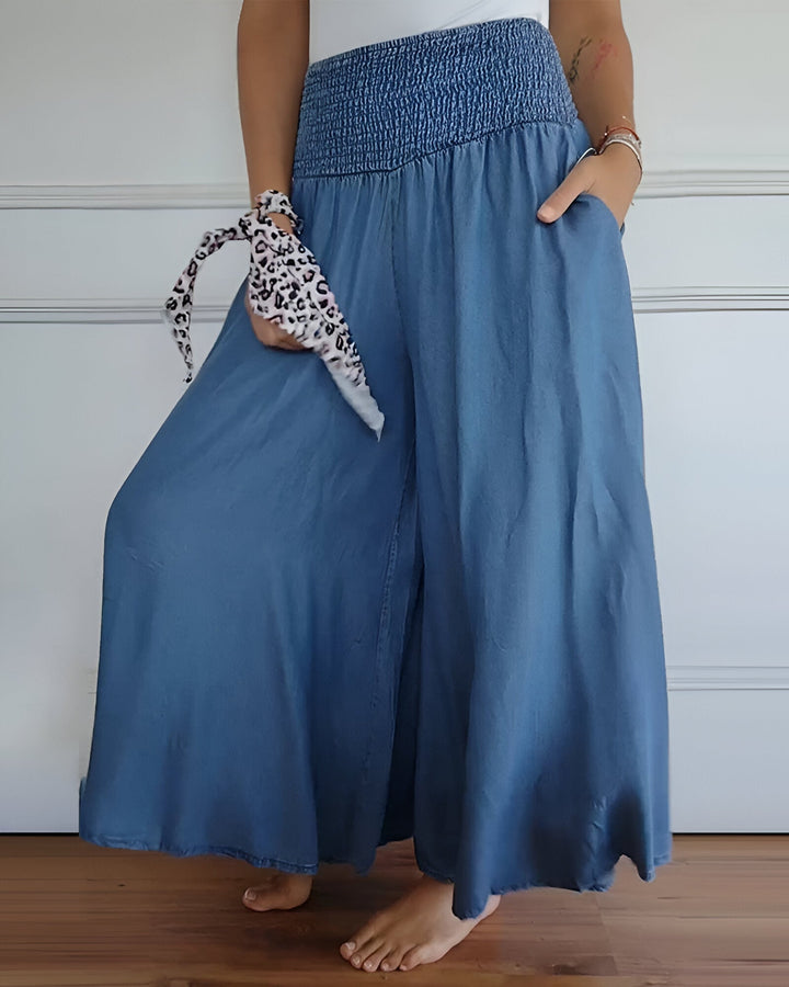 Long women's smocked maxi skirt featuring a wide waistband & practical side pockets. Great for summer fashion.