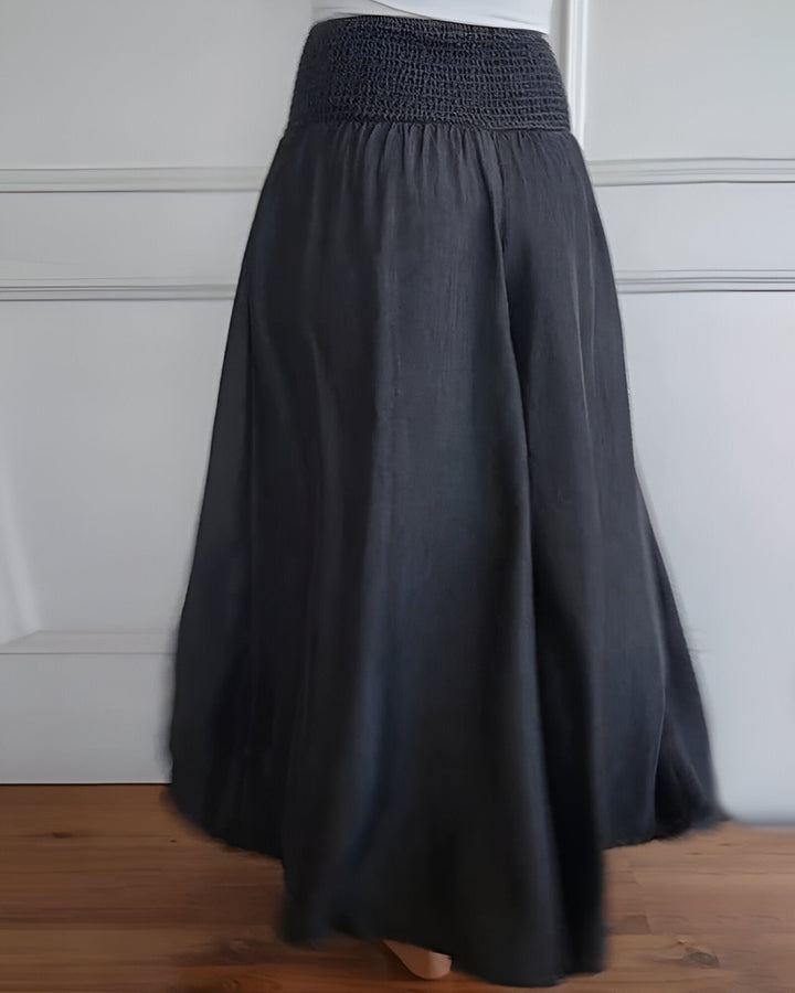 Versatile women's smocked maxi skirt with wide waistband and side pockets. Comfortable long flowy skirt.