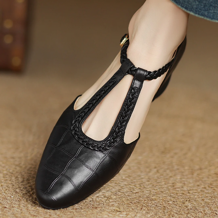 Chic women's leather Mary Janes with a unique braided T-strap, pointed toe, and low heel.