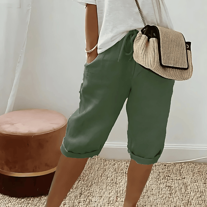 Soft, solid color knee-length women's harem shorts with a high-waist drawstring, ideal for casual comfort.