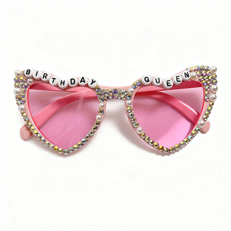 Close-up of sparkling rhinestone-embellished heart-shaped women's sunglasses.