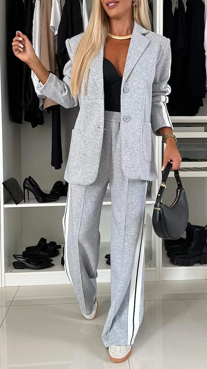 Women's sporty chic suit set with oversized blazer & striped trousers. Urban luxe two-piece for modern fashion.