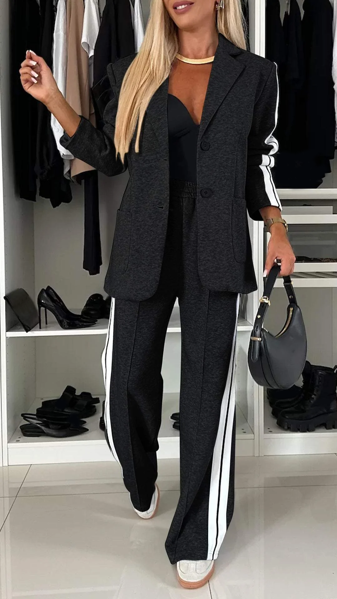 Full view of women's sporty chic suit set. Casual elegant two-piece with oversized blazer & striped pants.