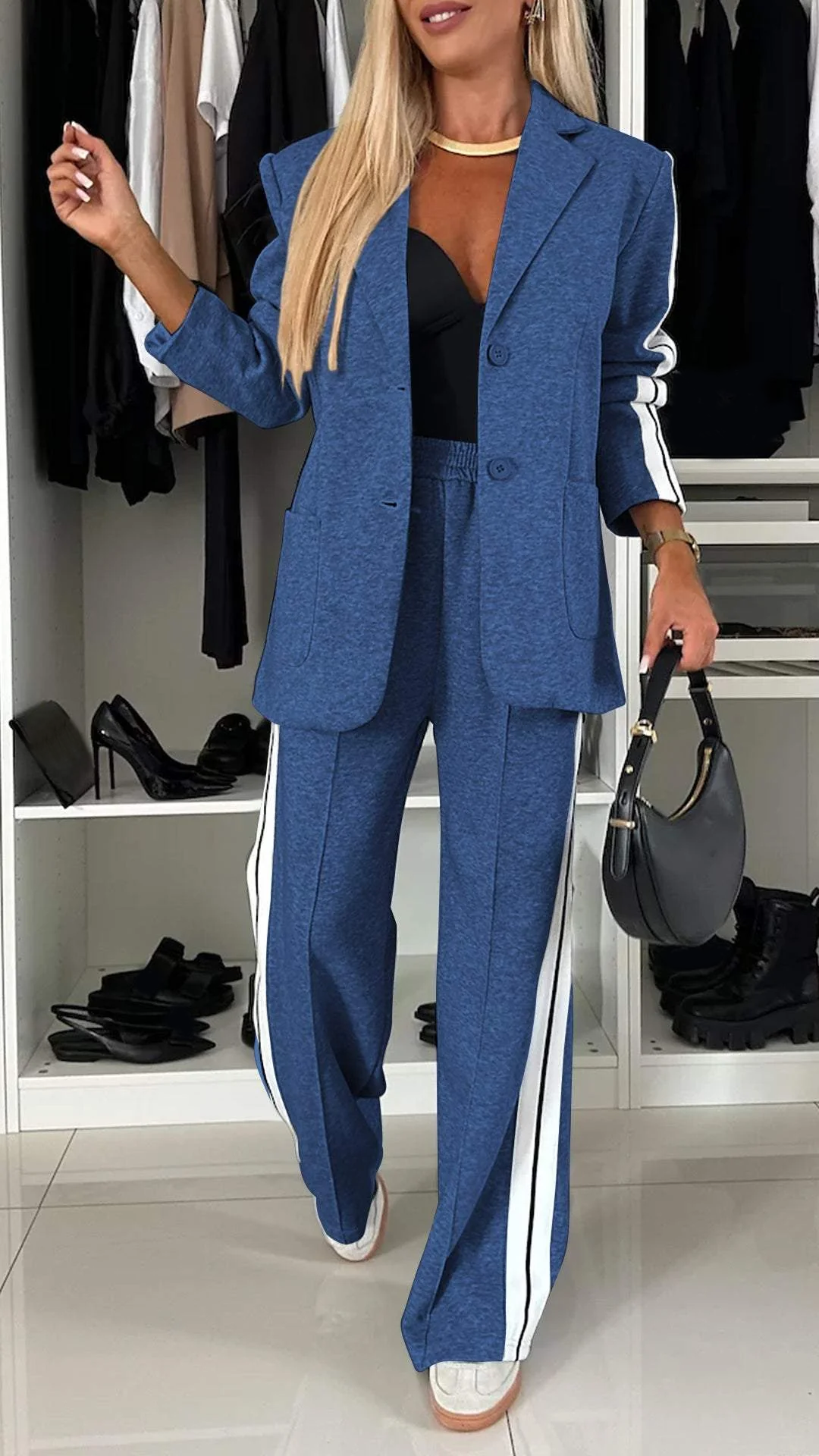 Angled shot of women's two-piece sporty chic suit. Elegant oversized blazer and striped trousers. Modern style.
