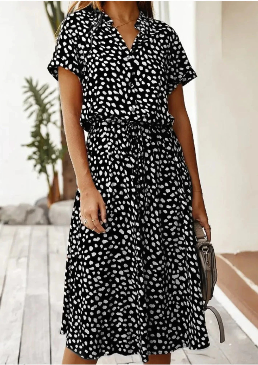 Elegant flowy spotted print women's midi dress with a full button-down design and a cinched drawstring.