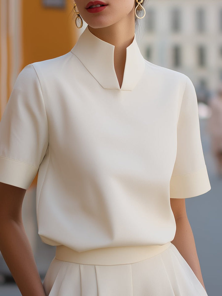 Chic minimalist women's structured blouse, short-sleeve with a sophisticated stand collar.