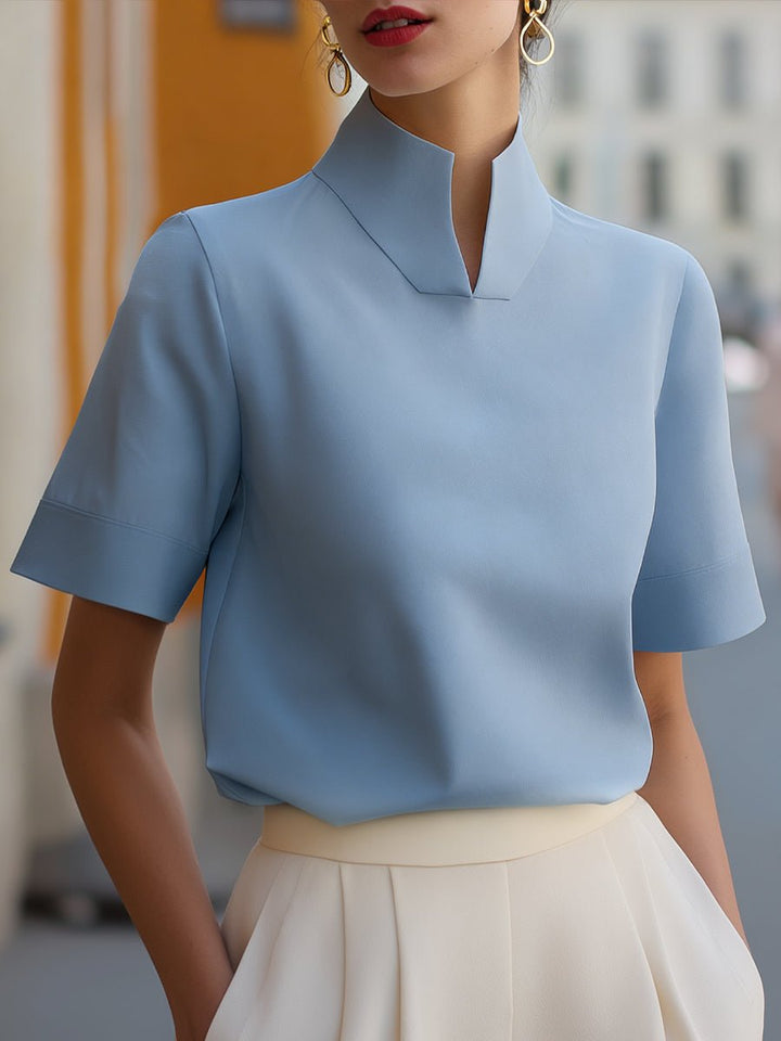Close-up of a women's stand-collar short-sleeve structured blouse, highlighting elegant fabric.