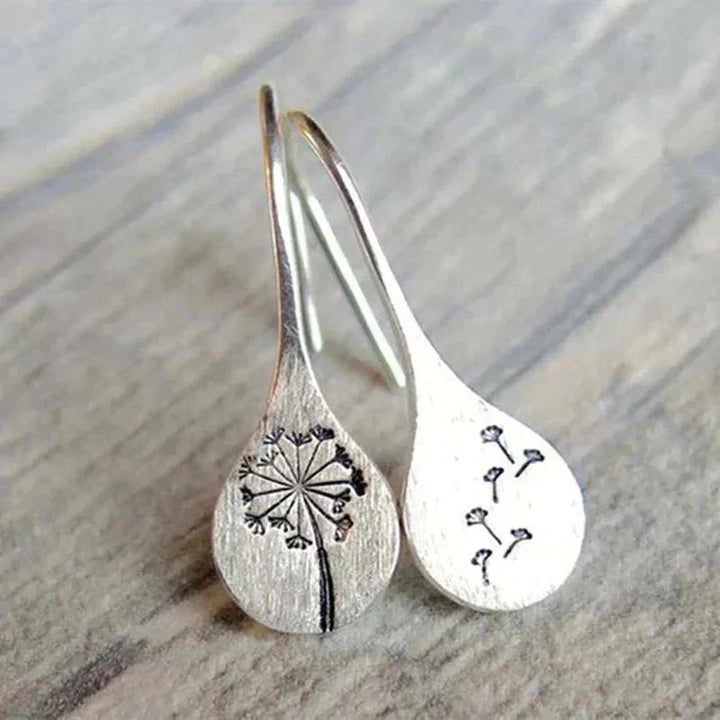 Women's sterling silver dandelion teardrop dangle earrings with delicate seed details, nature-inspired jewelry.