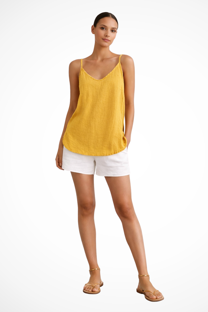 Relaxed fit women's cami top featuring thin straps, a flattering V-neck, and stylish curved hem.