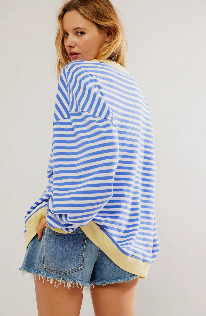 Woman modeling a comfortable striped crewneck sweater, showcasing effortless casual fashion.